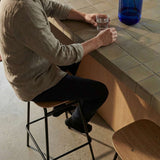 Frame Bar Stool med sæde i egefinér og stel i sort pulverlakeret stål i industrielt design.