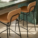Frame Bar Stool barstol med ryglæn i sort læder og sort pulverlakeret stålstel indendørs.