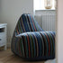 Lounge Chair og Pouf Paul Smith med multifarvet bomuldstekstil og moderne design i et hjemmemiljø.