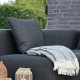 Sort Cobana Cushion i vandafvisende Olefin tekstil på udendørs sofa.