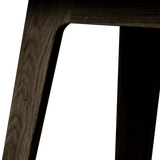 Nordic bænk i mørkt pigmenteret egetræ med Terra Black læderpolstring og glat træfinish.