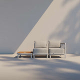 Kirra Lounge Sofa i sandfarvet med to sæder og matchende bord uden accessory fit i udendørs miljø.