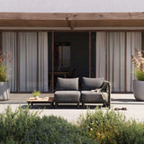 Kirra Lounge Sofa i sandfarvet med to sæder og matchende bord uden accessory fit i udendørs miljø.