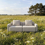 sackit Cobana loungesofa til to personer i lysegråt stof omgivet af blomstrende eng under åben himmel