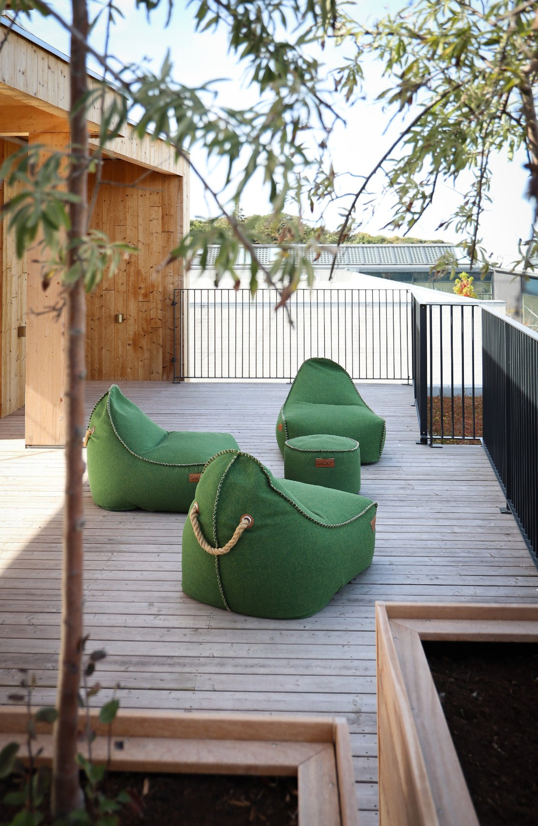 Loungeområde med flere grønne Cobana Lounge Chairs og Puffer fra SACKit på Hotel GSH