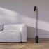 Sort Expo Floor gulvlampe med mat aluminium og marmorfod i moderne indendørs miljø.
