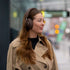 Kvinde iført brune Touch 310 over ear høretelefoner fra sackit på en byvej i beige frakke