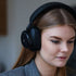 Kvinde iført sorte sackit Touch 400 over ear høretelefoner med støjreduktion i et stilrent design til fokuseret lytning