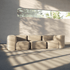 Blød beige indendørs sofa uden stel med modulær form og løse hynder i et lyst minimalistisk rum med varme solstriber fra vinduet fra sackit