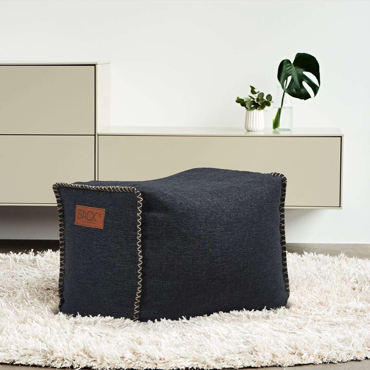 Cobana Square Pouf i sort Cobana stof med kvadratisk form og håndsyede sting.