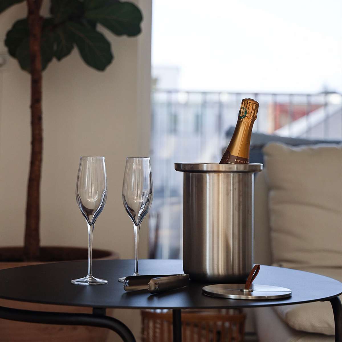 Satinpoleret rustfri stål vinkøler med læderhåndtag og låg, designet til at holde vin kølig.