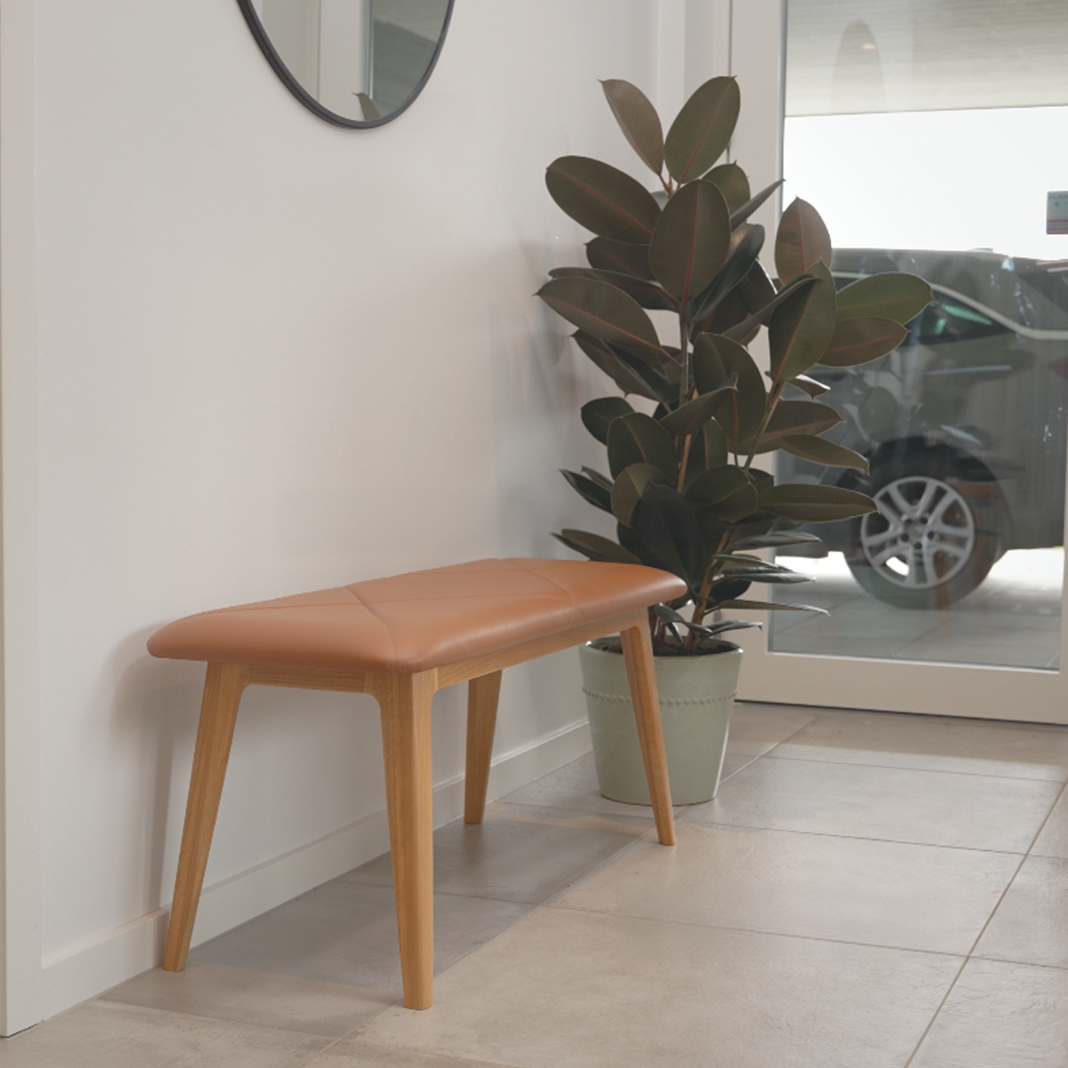 Nordic Bench i massivt egetræ med sort Terra læderpolstring og glat finish.