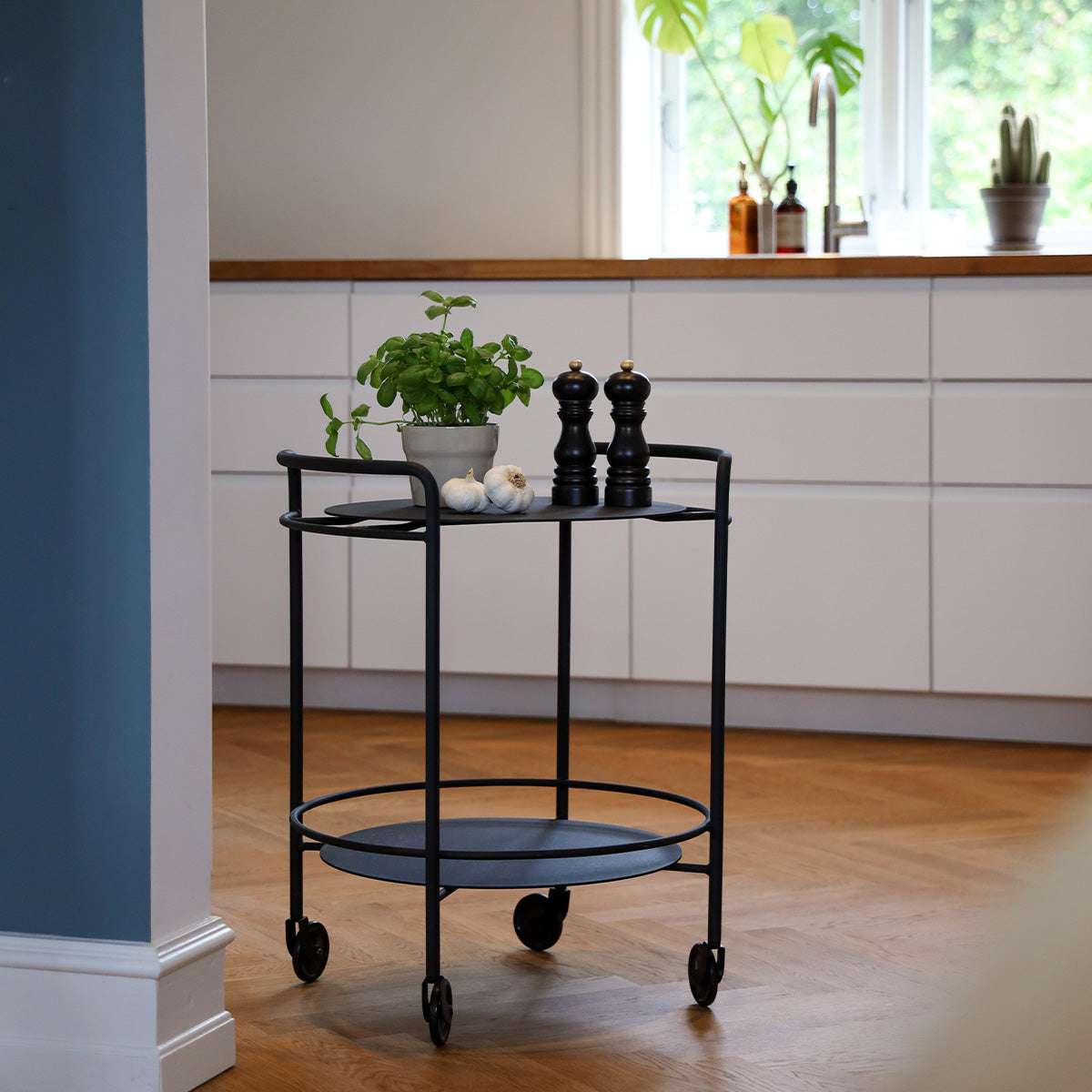 Sort Serving Table i mat pulverlakeret stål med hjul, designet af Steffensen & Würtz, brugt som sidebord.