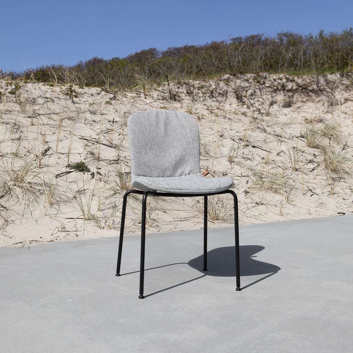 Patio Chair no. One S1 med taupe formstøbt skal og sort pulverlakeret stel på terrasse.