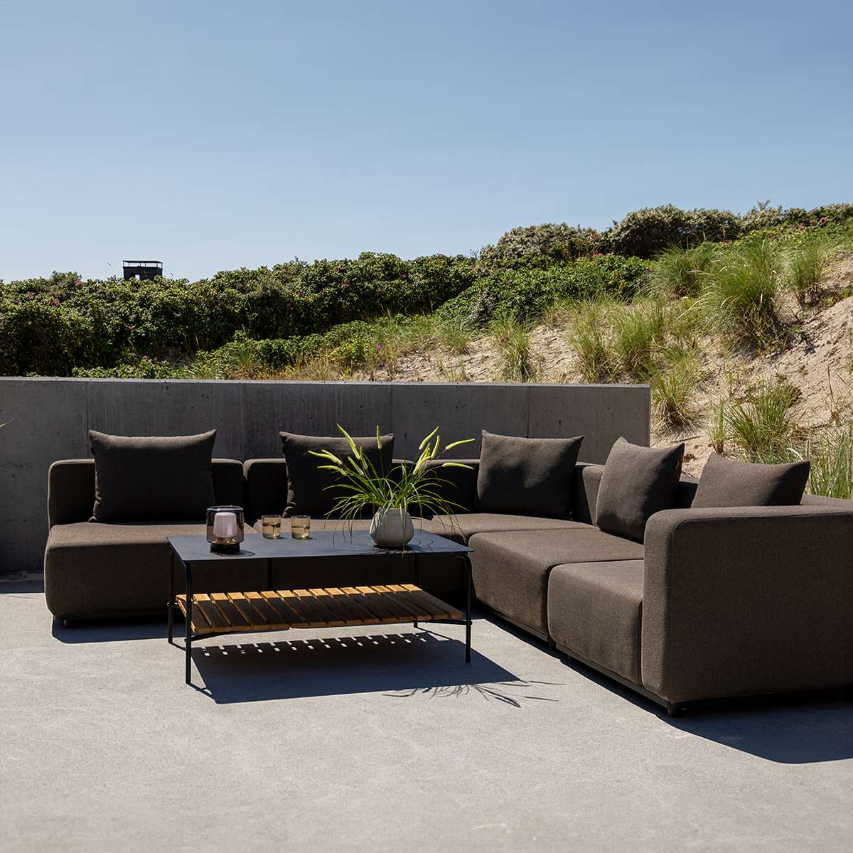 Sort Cobana Lounge Sofa i modulopbygget design med rene linjer og puder i udendørs miljø.