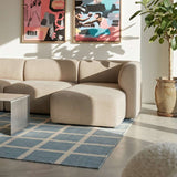 Beige Fjord sofa med højrevendt chaiselong fra sackit i en lys nordisk stue med kunst på væggen plante og grafisk tæppe