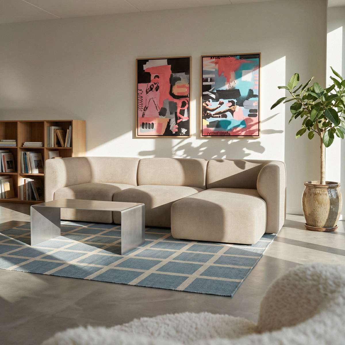 Beige modulsofa med højrevendt chaise i lys skandinavisk stue med kunst på væggen sofabord plante og blåt geometrisk tæppe fra sackit