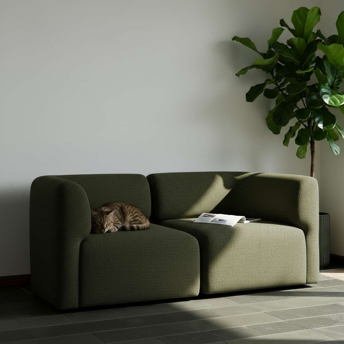 Grøn Fjord sofa til to personer i et lyst nordisk hjem med en kat på sædet og en stor grøn plante ved siden af