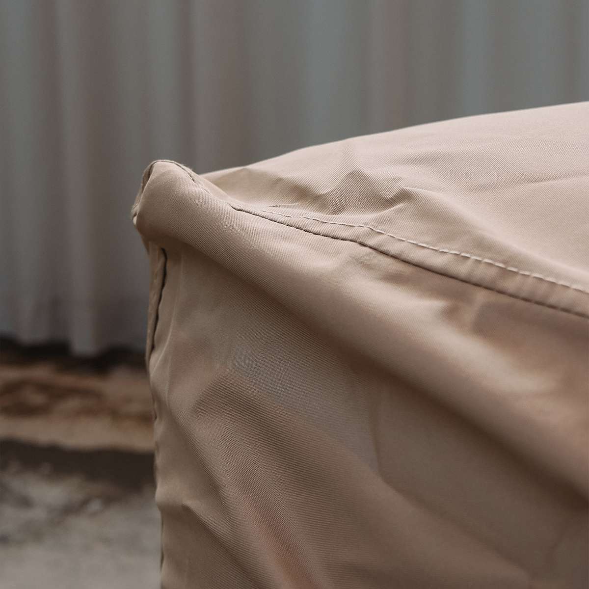 Nærbillede af sandfarvet vejrbestandigt cover til Cobana Lounge Sofa med syninger og beskyttende pasform til udendørs brug