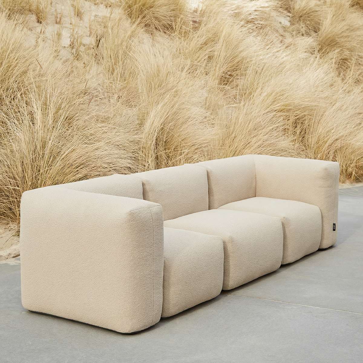 Udendørs Soft Sofa Outdoor 3-personers i beige bouclé med bløde puder og lav ryg.