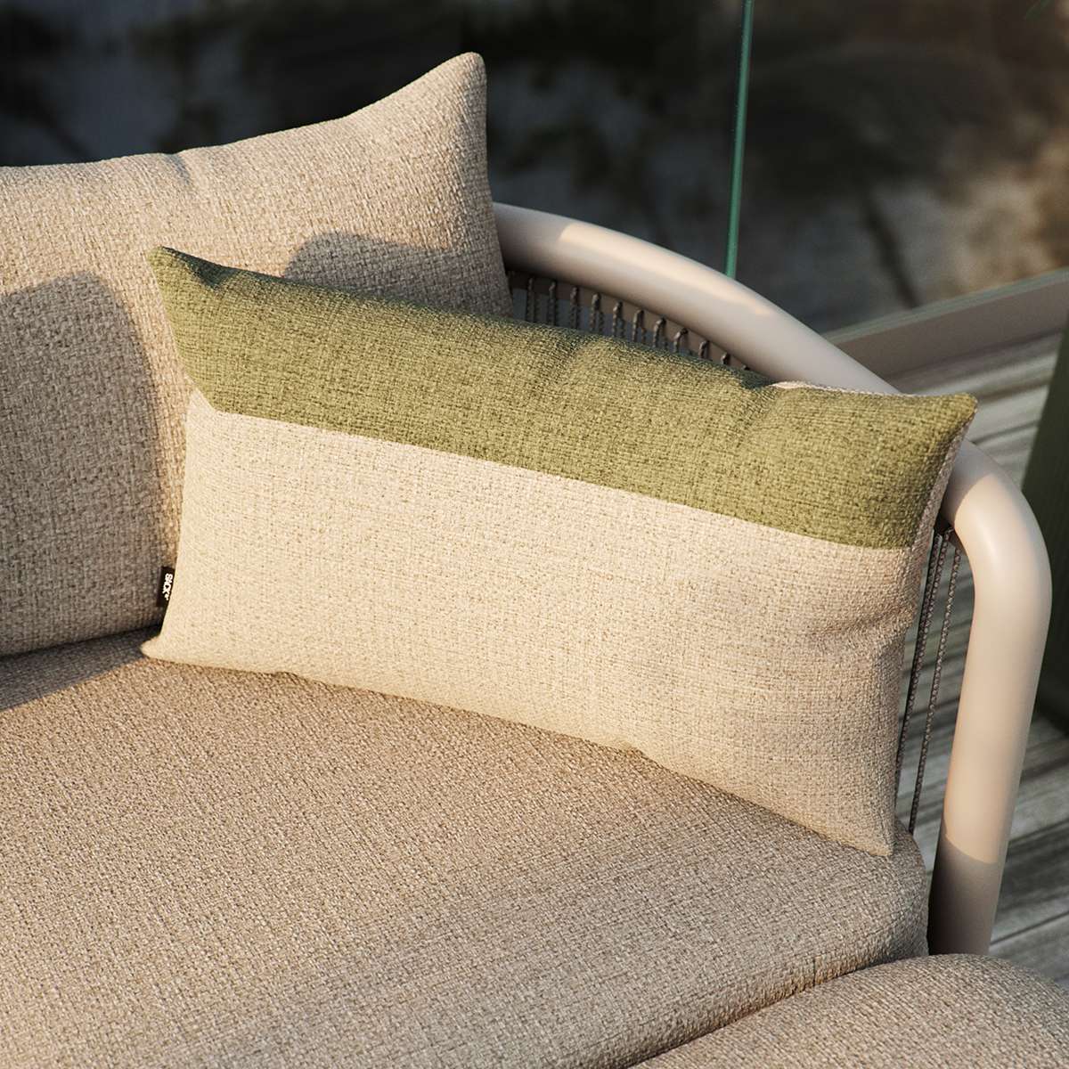 Tide Cushion i sand og indigo farver, blød udendørspude med farveblokke på lounge-møbel.