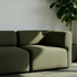Olivengrøn Fjord sofa fra sackit med bløde afrundede former i et lyst nordisk hjem med sollys og grøn plante i baggrunden