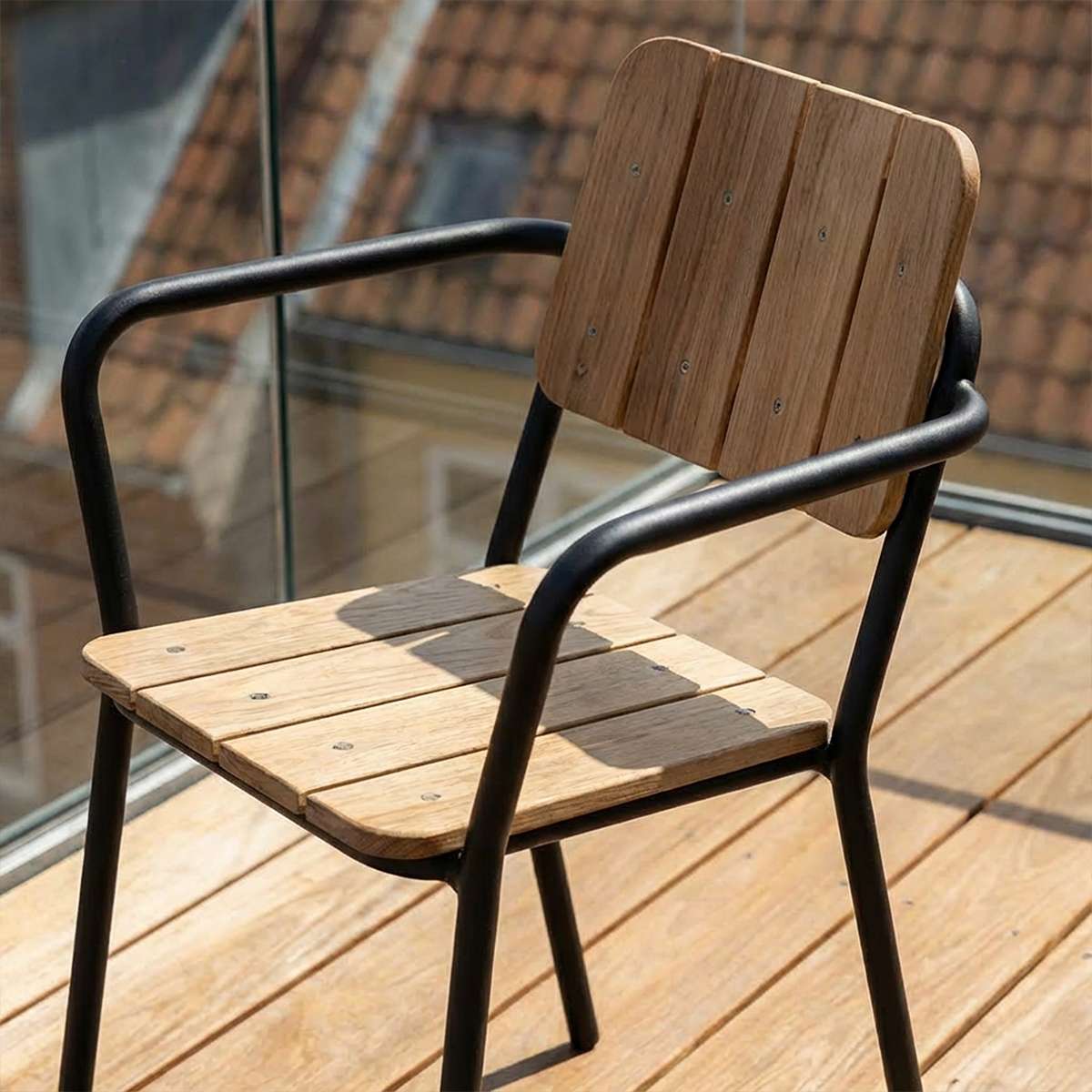 Udendørs Kirra Patio Chair i sort pulverlakeret aluminium og ubehandlet teaktræ med armlæn.