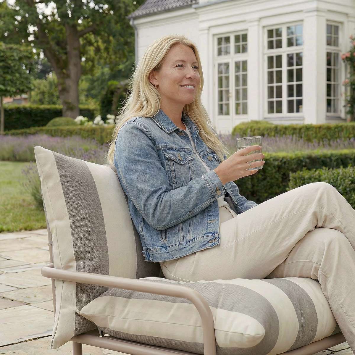 Mollis Lounge Chair i Renesse Taupe med pulverlakeret aluminiumsramme og eco-certificeret tekstil i udendørsmiljø.