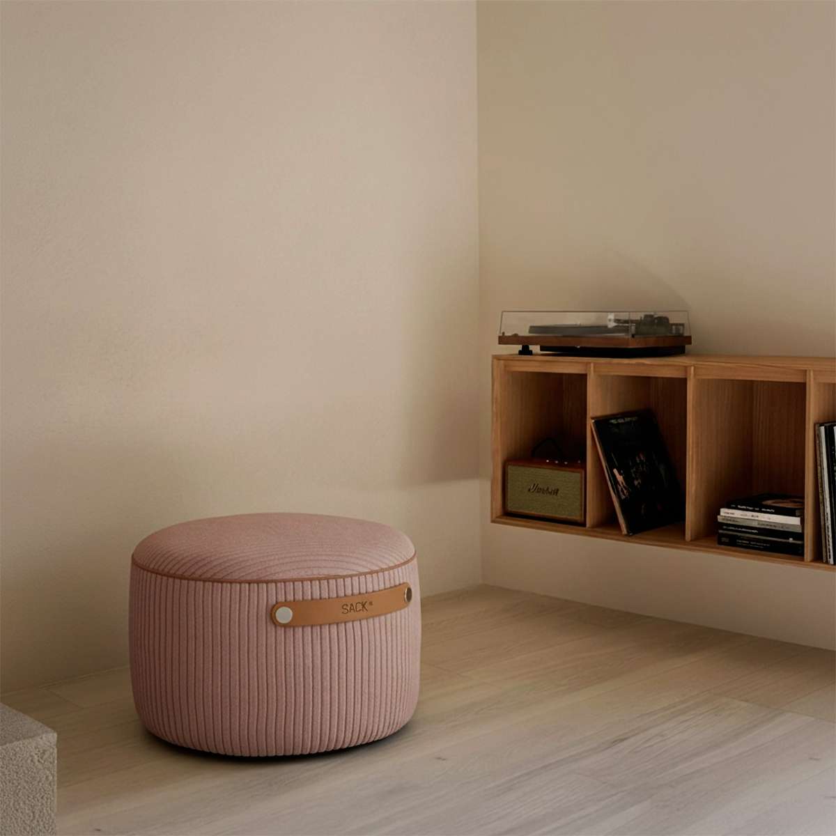 Lyserød SACKit Pouf Indoor i corduroy med læderhåndtag i et moderne interiør.