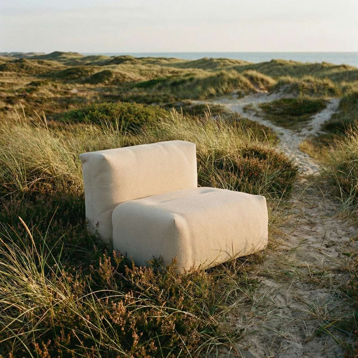Udendørs Soft Sofa Outdoor sæde i blødt stof med neutral farve, designet til komfort i haven.